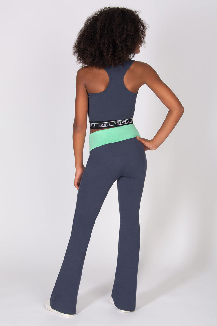 Girl wearing a dark grey flared jersey trousers with mint green fold-over waistband with matching tank top on a light grey background