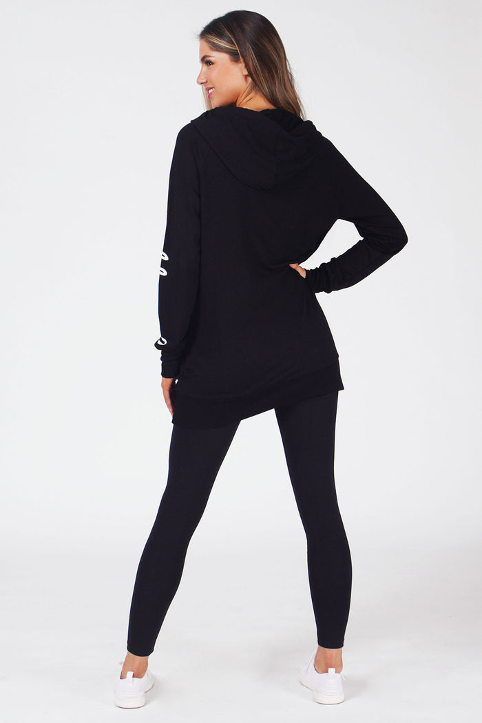 Woman wearing Black Longline Hoodie with logo on left sleeve