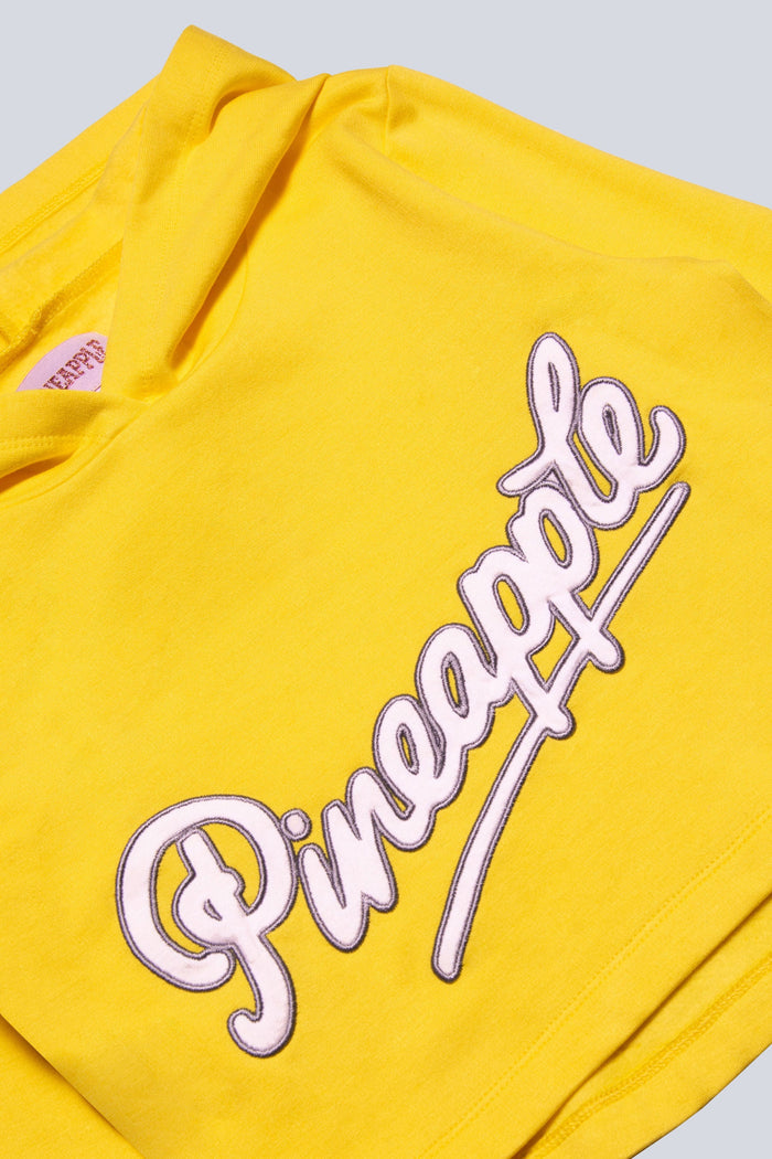 Detail shot of Pineapple Dance hoodie featuring a bold yellow logo chest print.