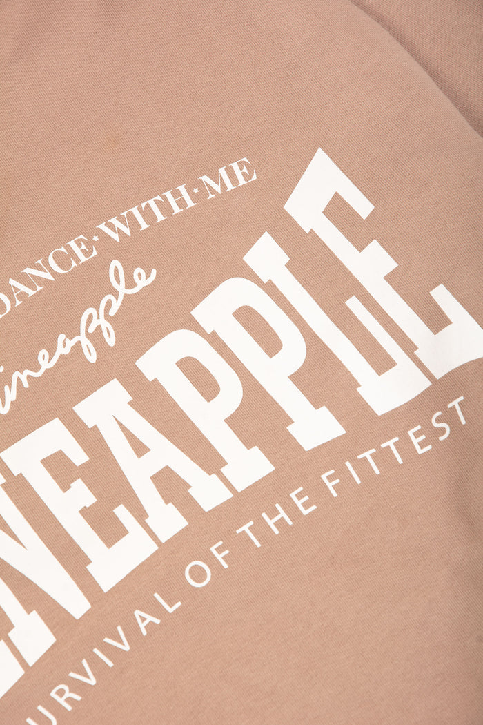 Detail shot of white chest print featuring Pineapple Survival Of The Fittest logo