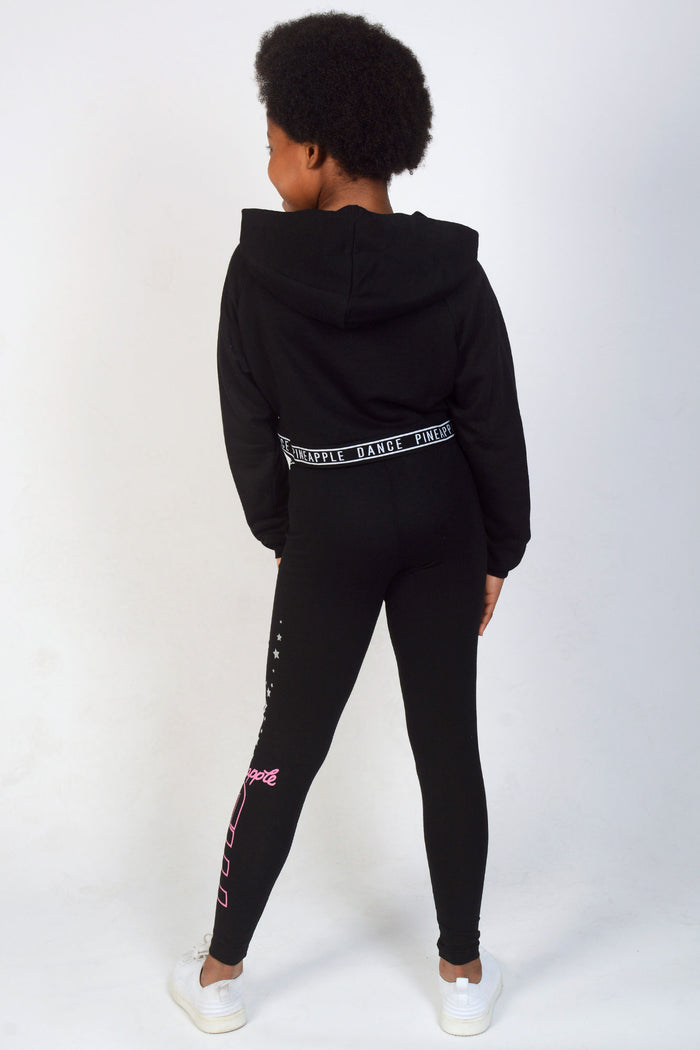 Girl wearing Black TNS Crop Hoodie and leggings
