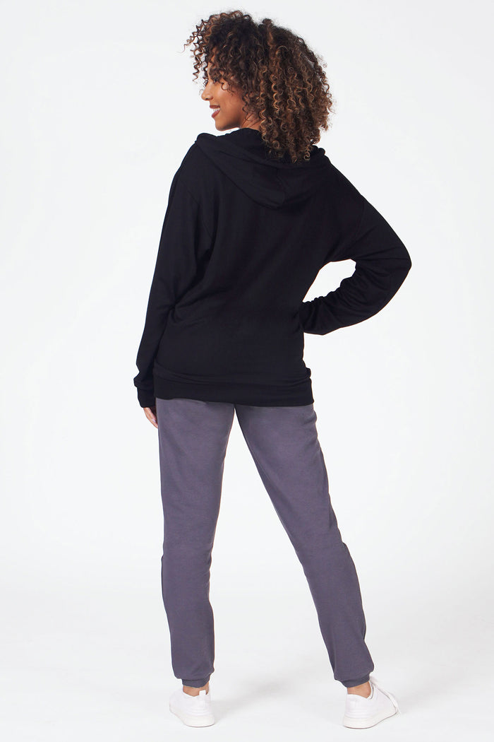 Woman wearing black zip front hoodie and grey joggers