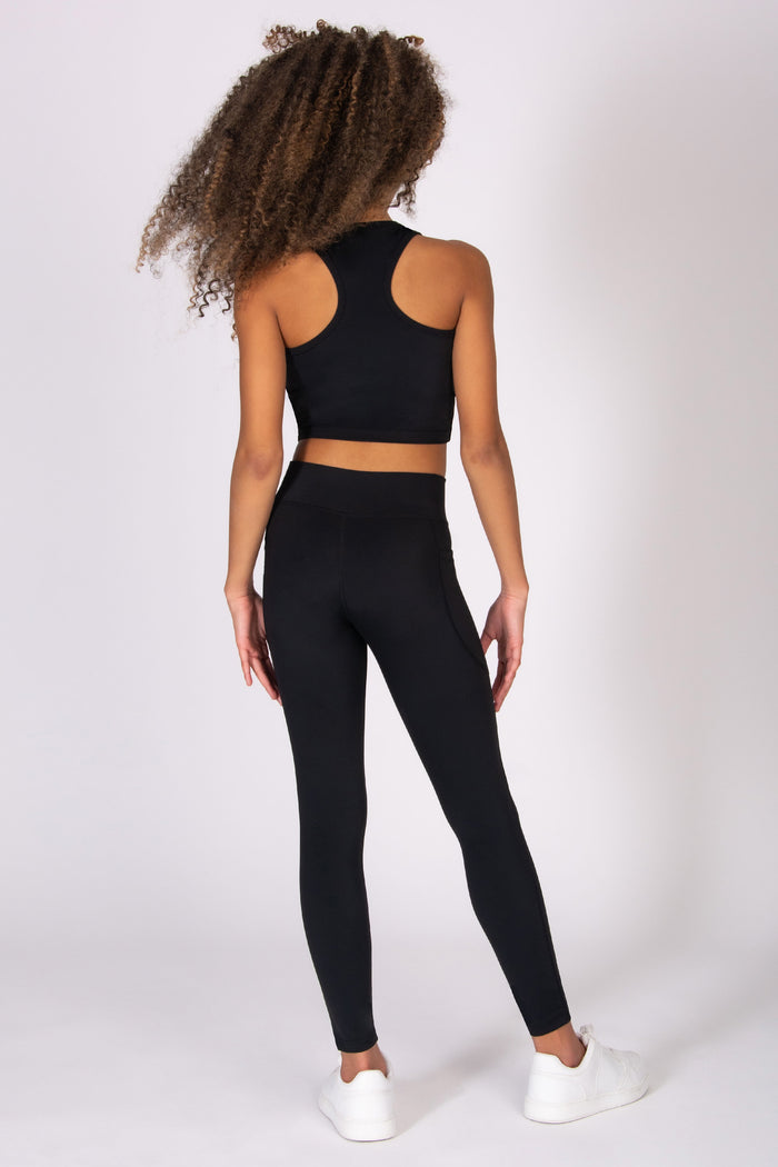 Girl wearing a black athletic outfit on a white background