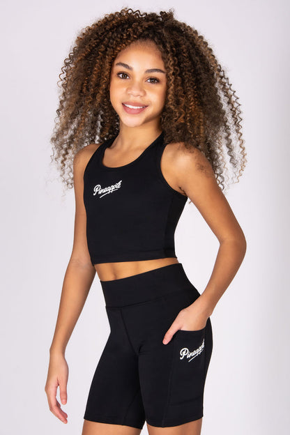 Girl wearing a black sports vest with shorts on a white background