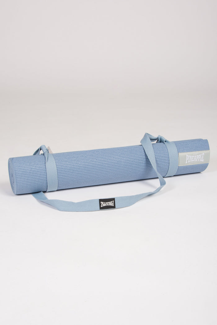 Foam yoga mat in light blue colour with matching carrying straps