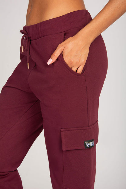 Maroon cargo joggers with pockets and a brand logo on a plain background