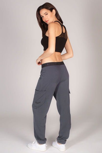 Dark grey combat joggers with large pockets worn with black crop top by Debbie Moore.