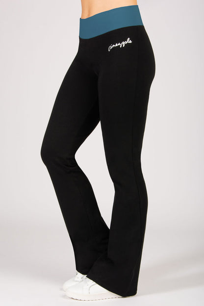 Black yoga pants with teal waistband featuring a brand logo on a white background