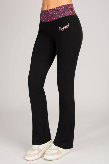 Black pants with a burgundy animal pattern waistband and logo on a grey background