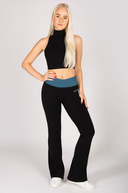 Woman wearing a black sleeveless top and black flared pants on a white background