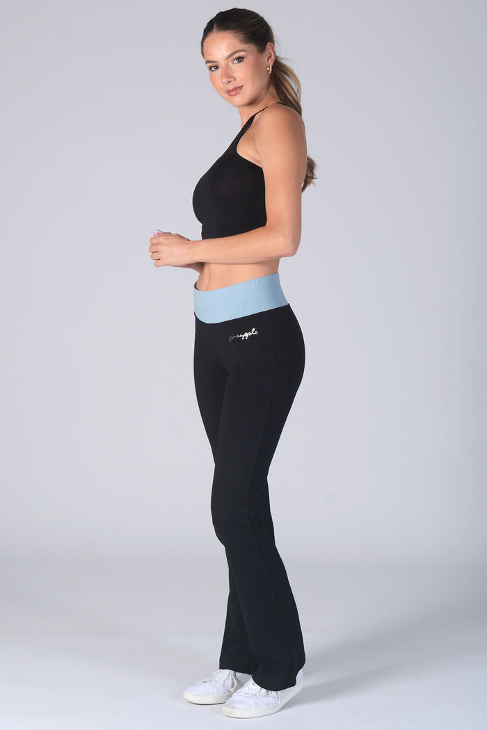 Woman wearing black Contrast Band Jersey Trousers with blue waistband and black Monroe vest