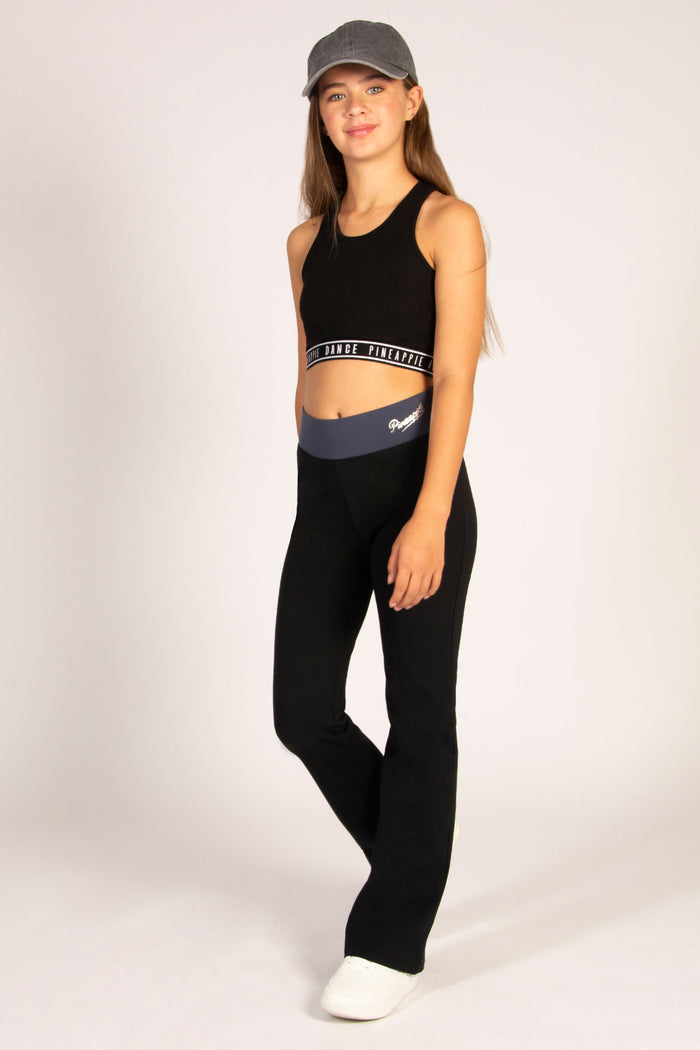 Black flared leggings for teenagers made of cottonelastane featuring a wide elasticated waistband for support.