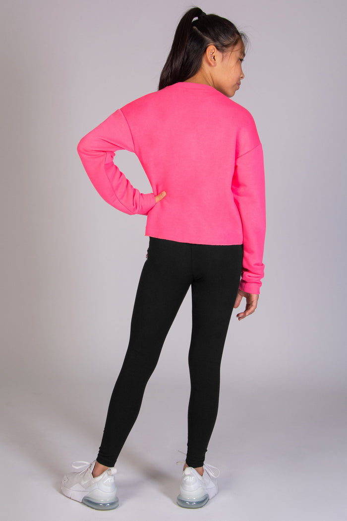 Girls' black basic leggings worn with neon bright pink sweat top designed by Pineapple.