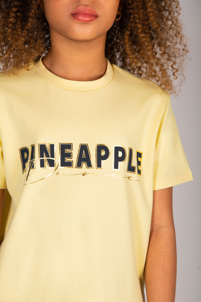 Butter yellow t-shirt with gold "Dance" print across the chest.