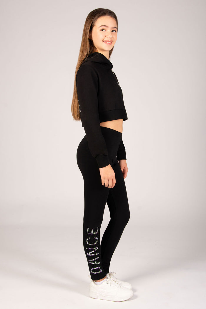 Person wearing a black outfit with 'DANCE' on leggings against a white background