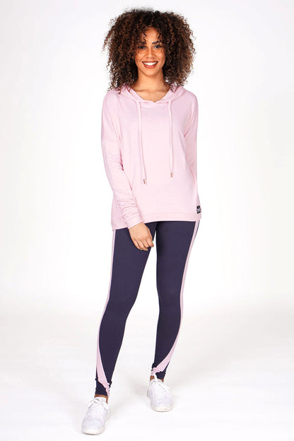 Woman wearing Pink Dip Hem Hoodie and charcoal racer leggings with pink stripes