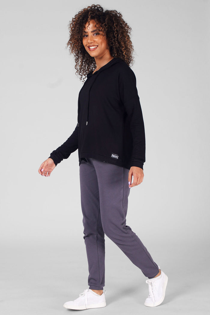 Woman wearing Black Dip Hem Hoodie and charcoal joggers