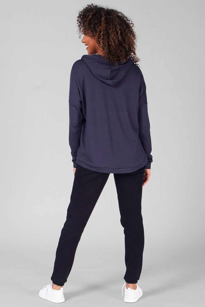 Woman wearing Charcoal Dip Hem Hoodie and black casual trousers