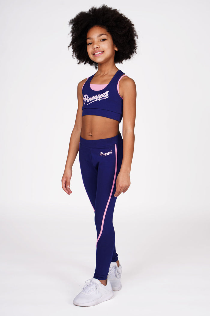Girl wearing Pineapple navy double layer bra and navy piping leggings