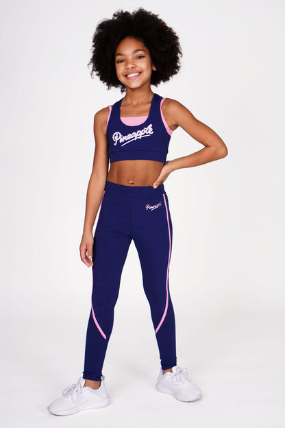 Girl wearing Pineapple navy double layer bra and navy piping leggings