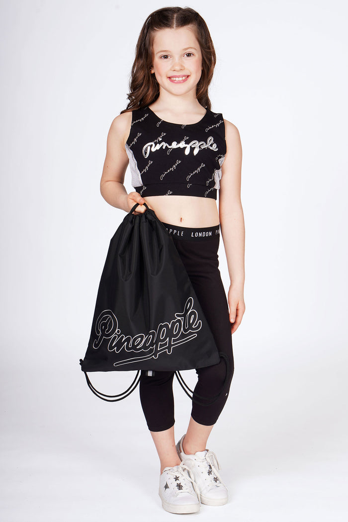 Girl carrying Black Drawstring Bag with white logo