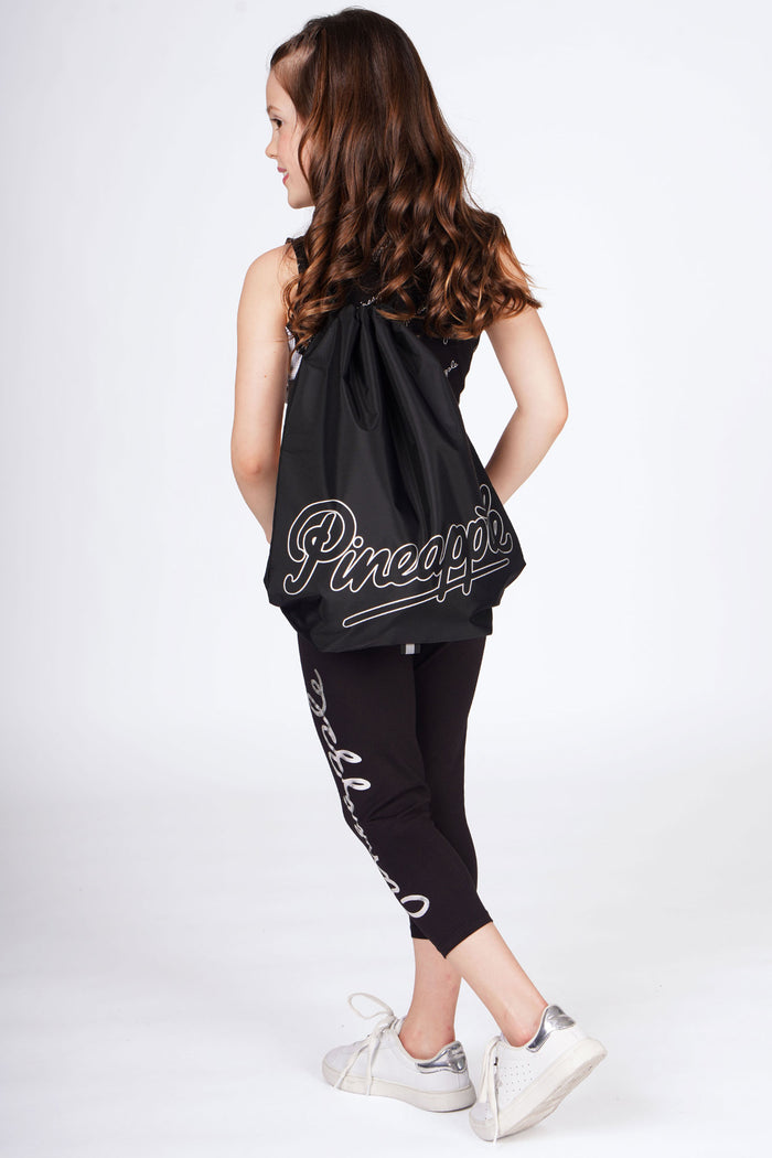 Girl carrying Black Drawstring Bag with white logo over her shoulder