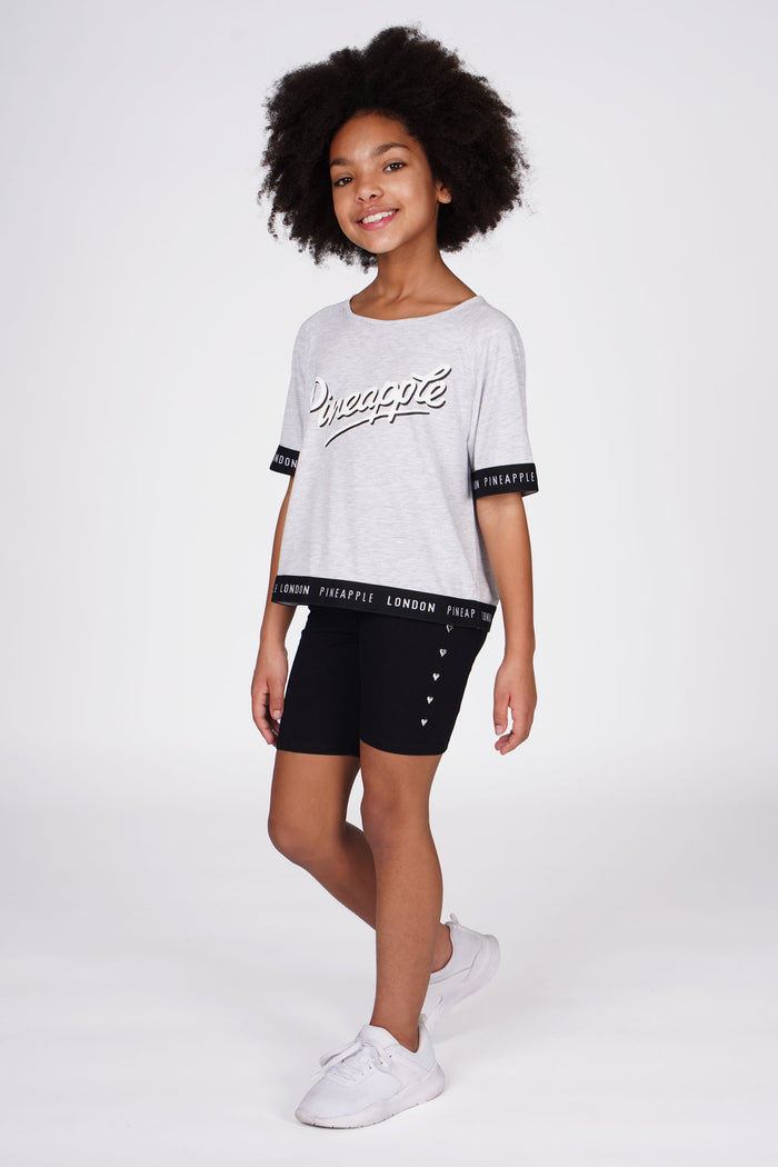 Girl wearing Heart Stud Black Cycling Shorts and grey jacquard t-shirt with contrast sleeves