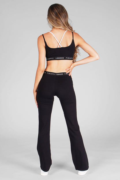 Woman wearing Black Jacquard Band Jersey Trousers and Black Bra Top with black and white straps