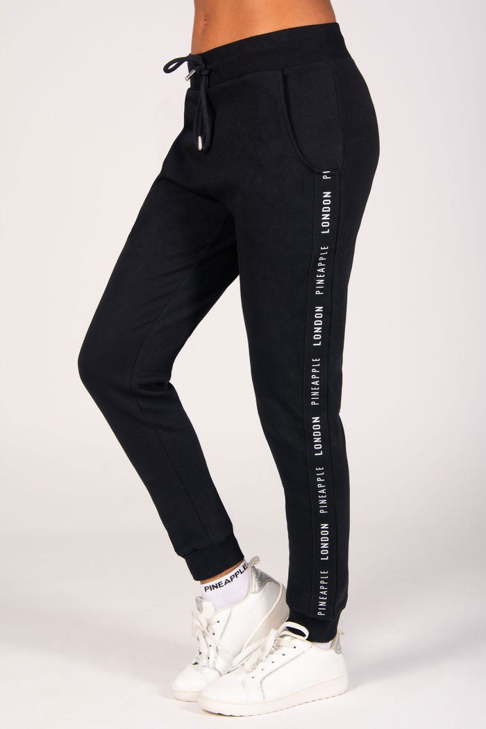 Women's black jacquard tape joggers with two side pockets, elasticated waistband and cuffs, and adjustable drawcords for a personalised fit.
