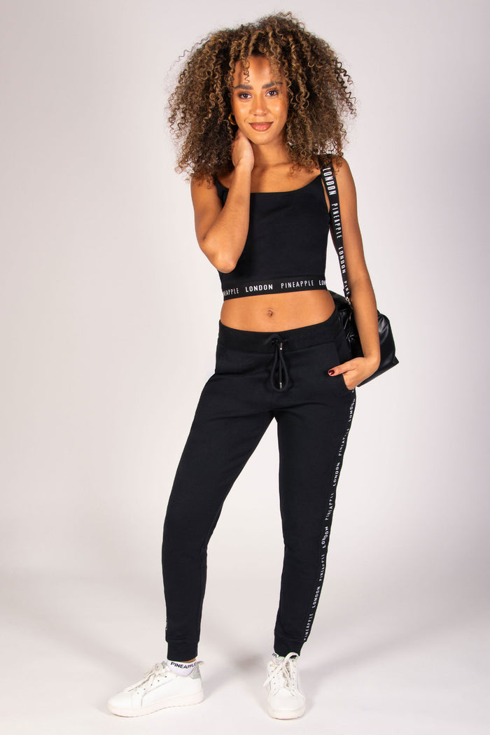 Woman wearing black joggers with jacquard tape, 2 pockets, adjustable drawcord and elasticated waistband.