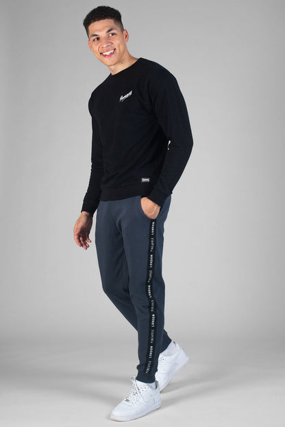 Man wearing charcoal Jacquard Joggers with pockets and black sweatshirt with white logo