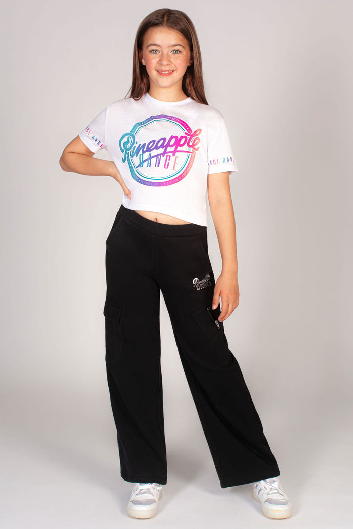 White crop top for girls worn with black wide leg cargo joggers for kids by Pineapple Dance Studios