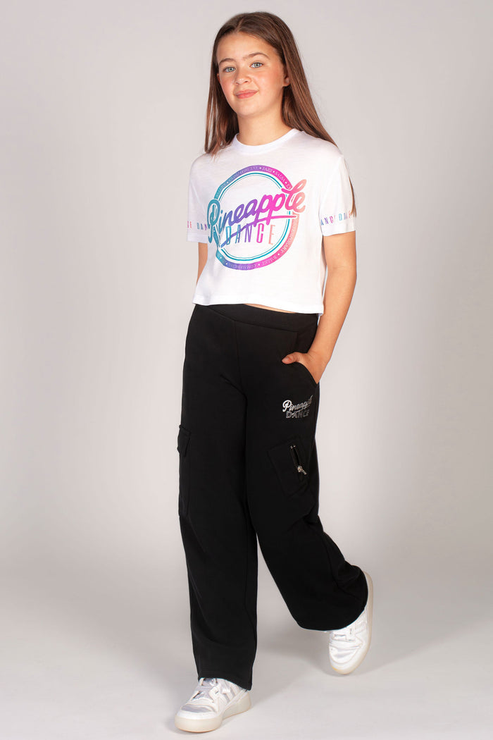 Girls' white crop t-shirt with rainbow print across the chest by Pineapple Dance Studios