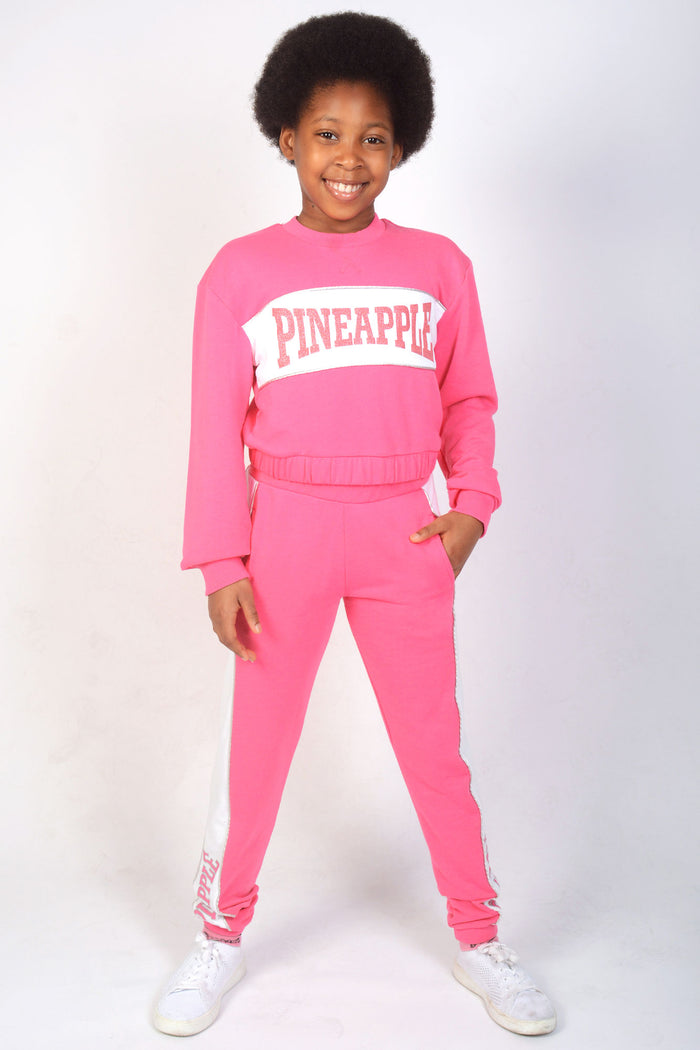Girl wearing Pink Joggers with white side panels and matching sweat top