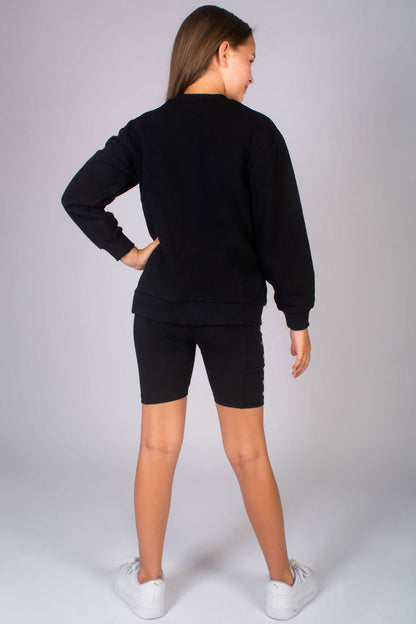 Girls' black long sleeve jumper with crew neck paired with dance cycling shorts for kids