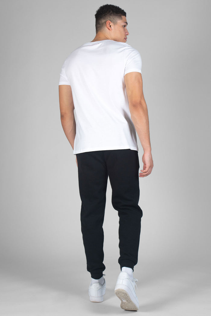 Man wearing white T-Shirt and black jogging trousers