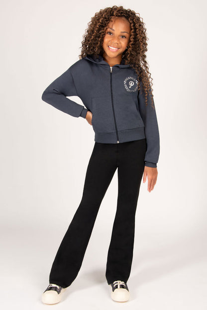 Child wearing a dark grey hoodie with black flared trousers on a white background