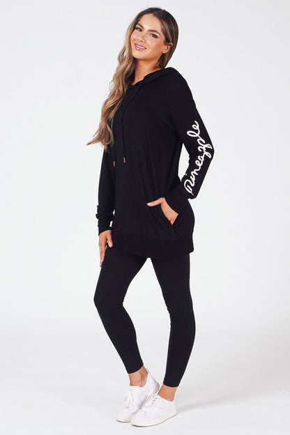 Woman wearing Black Longline Hoodie with white logo on left sleeve