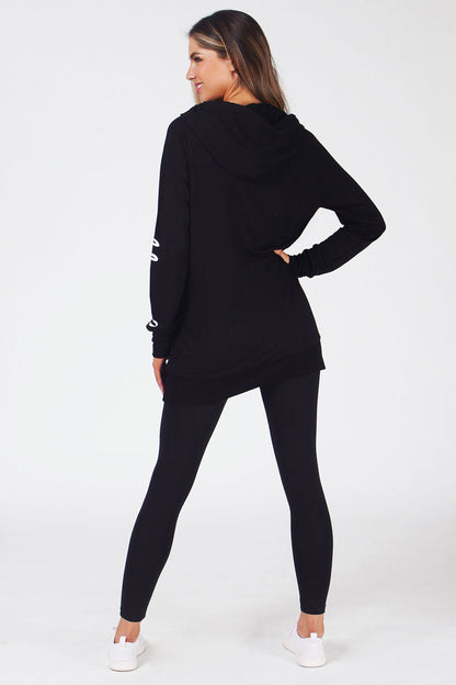 Woman wearing Black Longline Hoodie with logo on left sleeve