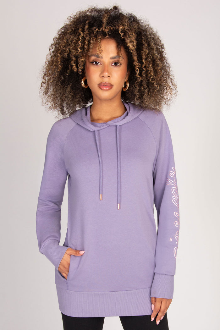 Woman wearing a light purple hoodie with a plain background