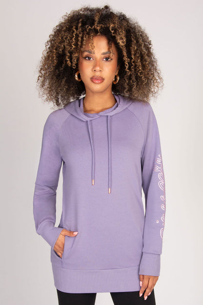 Woman wearing a light purple hoodie with a plain background