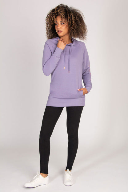Woman wearing a purple hoodie and black leggings on a white background