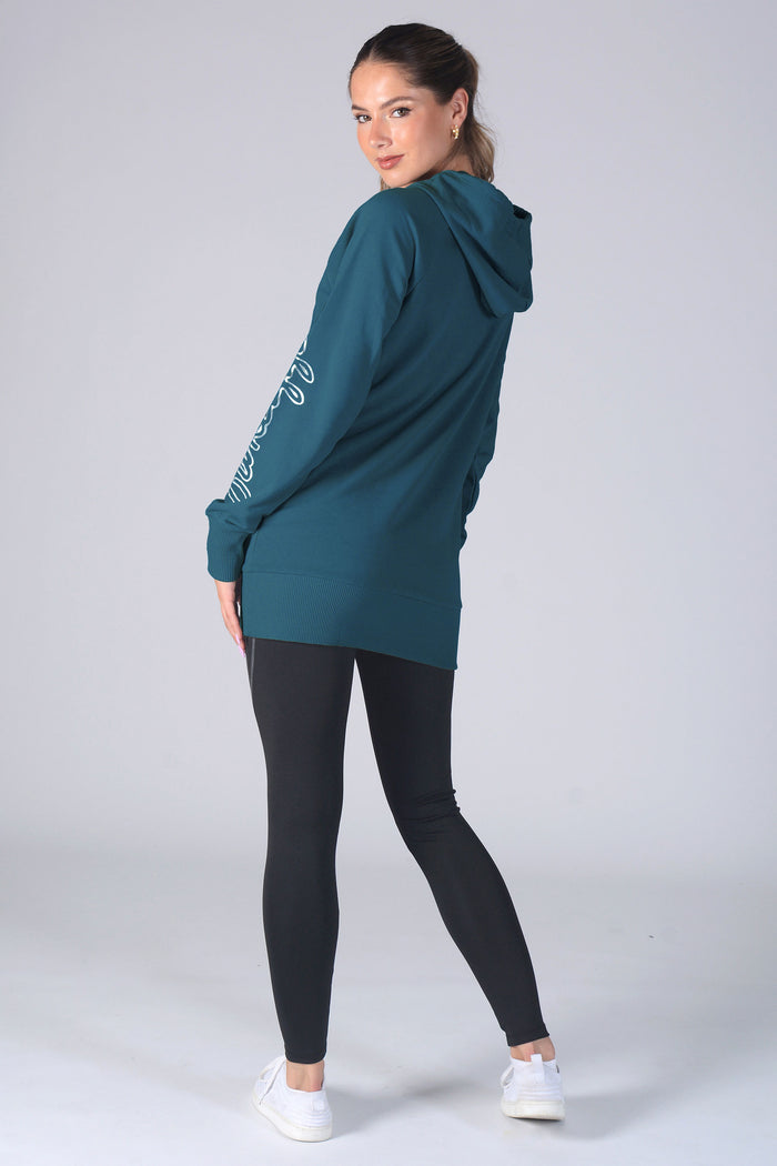 Woman wearing a blue hoodie and black leggings on a white background