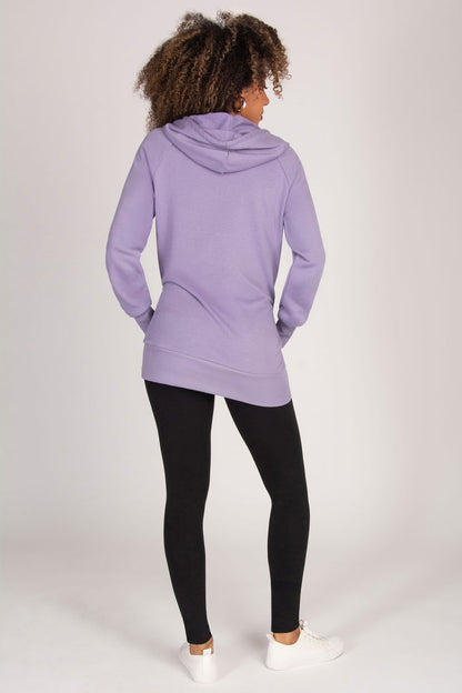 Woman wearing a purple hoodie and black leggings on a white background