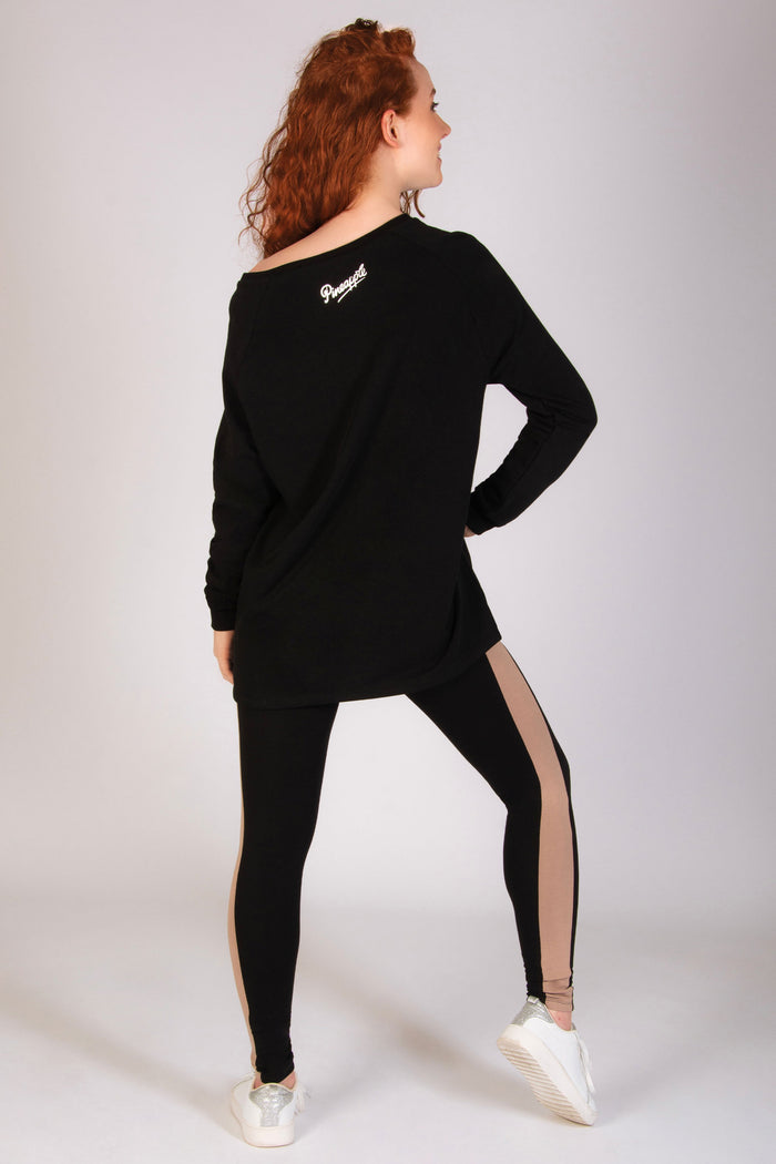 Black longline off-shoulder sweater for women paired with panel dance leggings.
