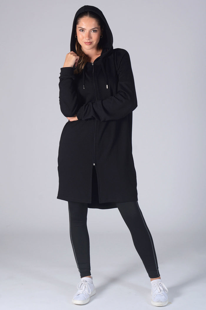 Woman wearing black Longline Hooded Zip Jacket and black leggings with pockets