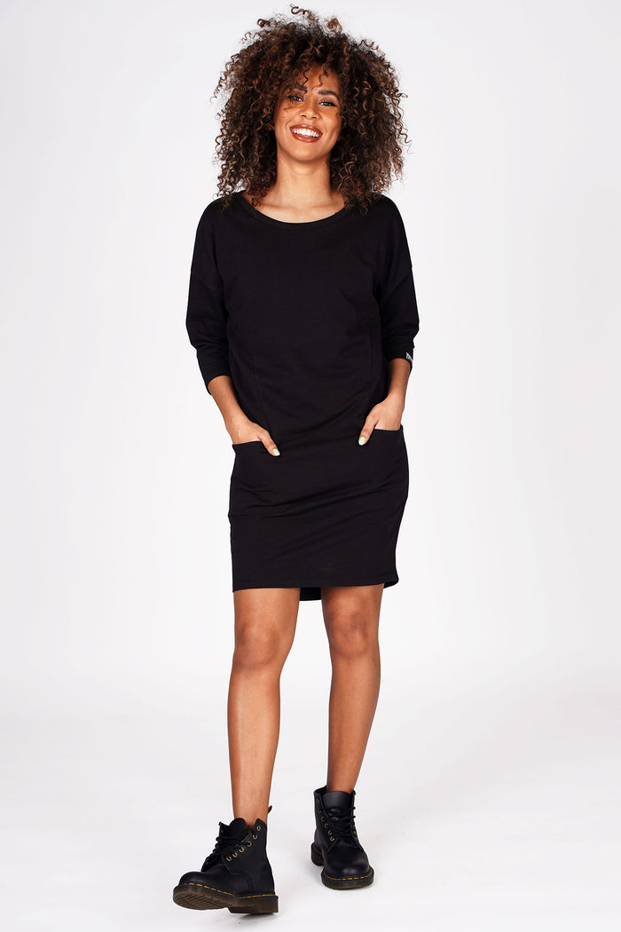 Woman wearing Pineapple Black Loopback Pocket Dress with three quarter sleeves and boots