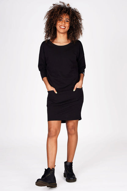 Woman wearing Pineapple Black Loopback Pocket Dress with three quarter sleeves and boots
