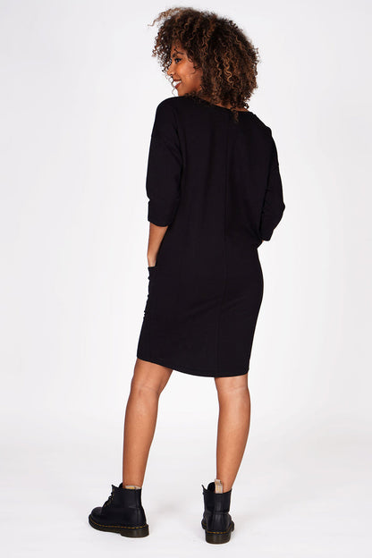 Woman wearing Pineapple Black Loopback Pocket Dress with three quarter sleeves with black boots