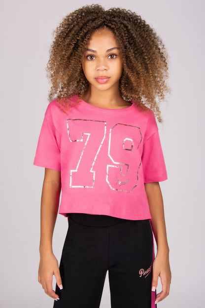 Person wearing a pink t-shirt with the number 79 and black pants on a plain background